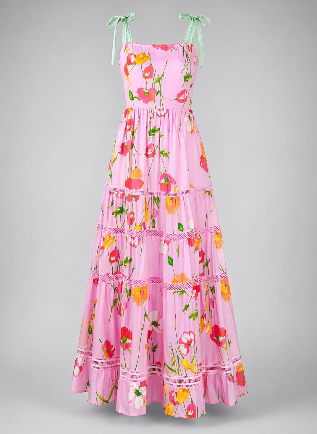 Pink floral dress with green straps on a gray background
