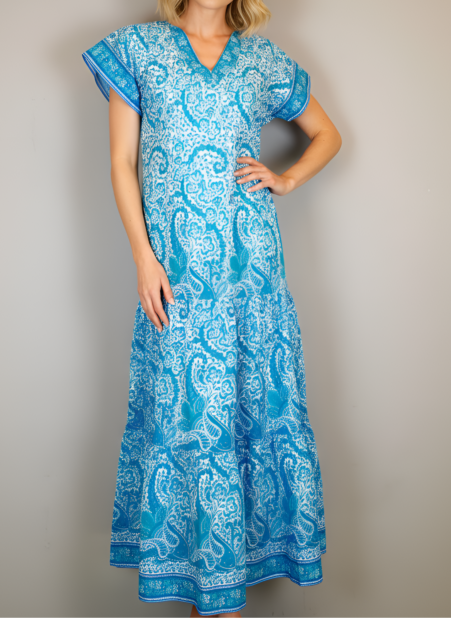 Woman wearing a blue patterned dress against a plain background