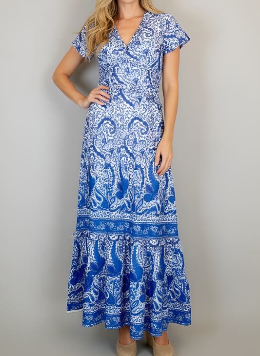 Woman wearing a blue and white patterned dress against a plain background