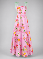 Pink floral dress with green straps on a gray background