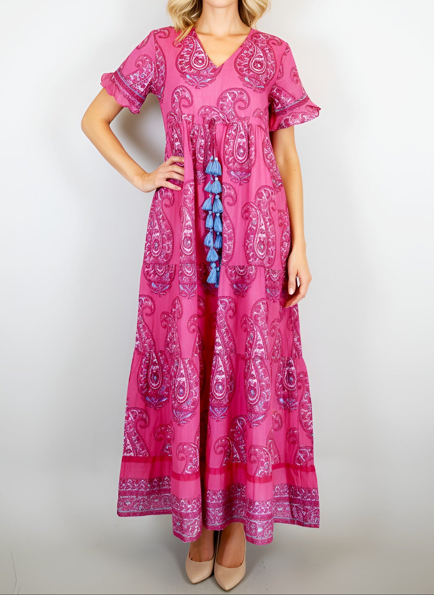 Woman wearing a pink patterned dress with blue accents on a white background