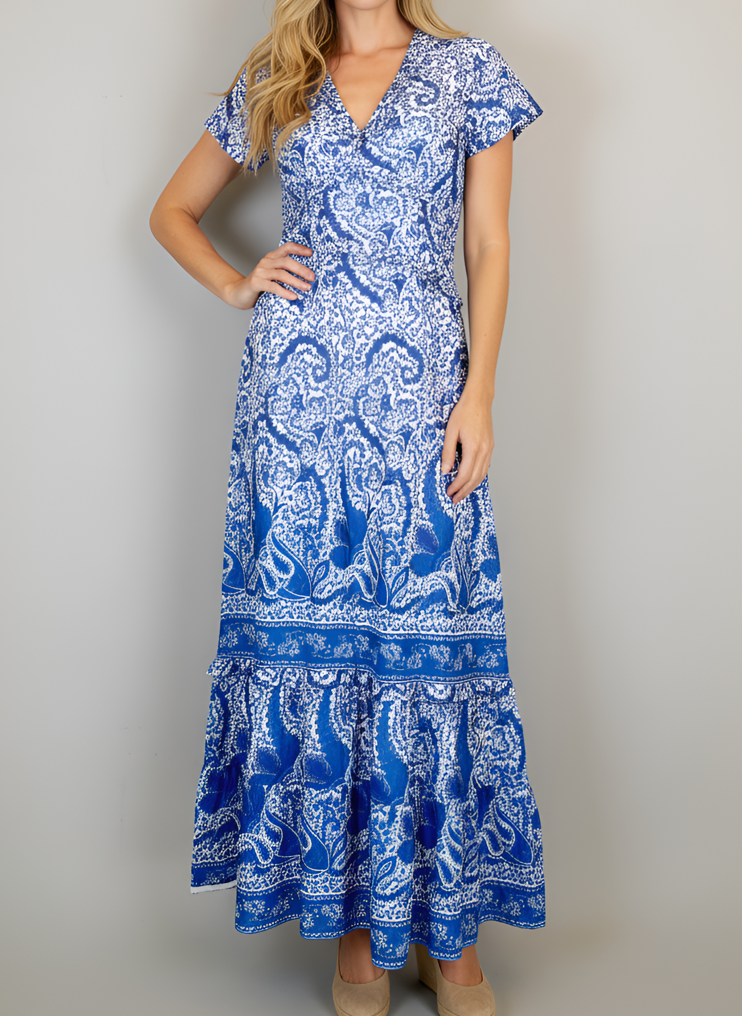 Woman wearing a blue and white patterned dress against a plain background
